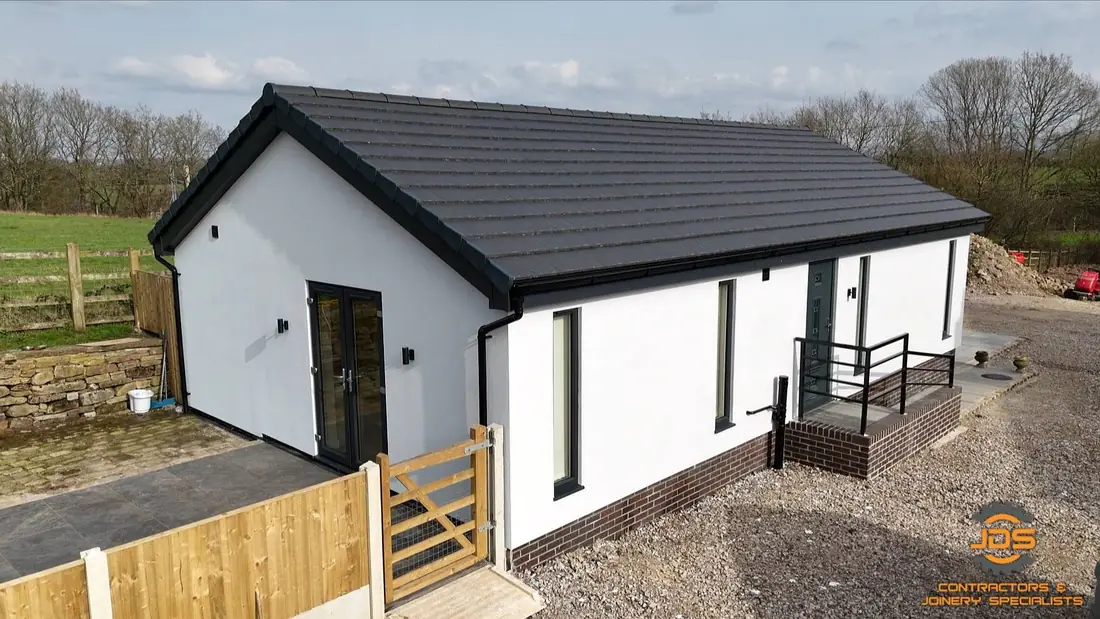 Aerial view of the completed Charnock Richard new build beside the original farmhouse